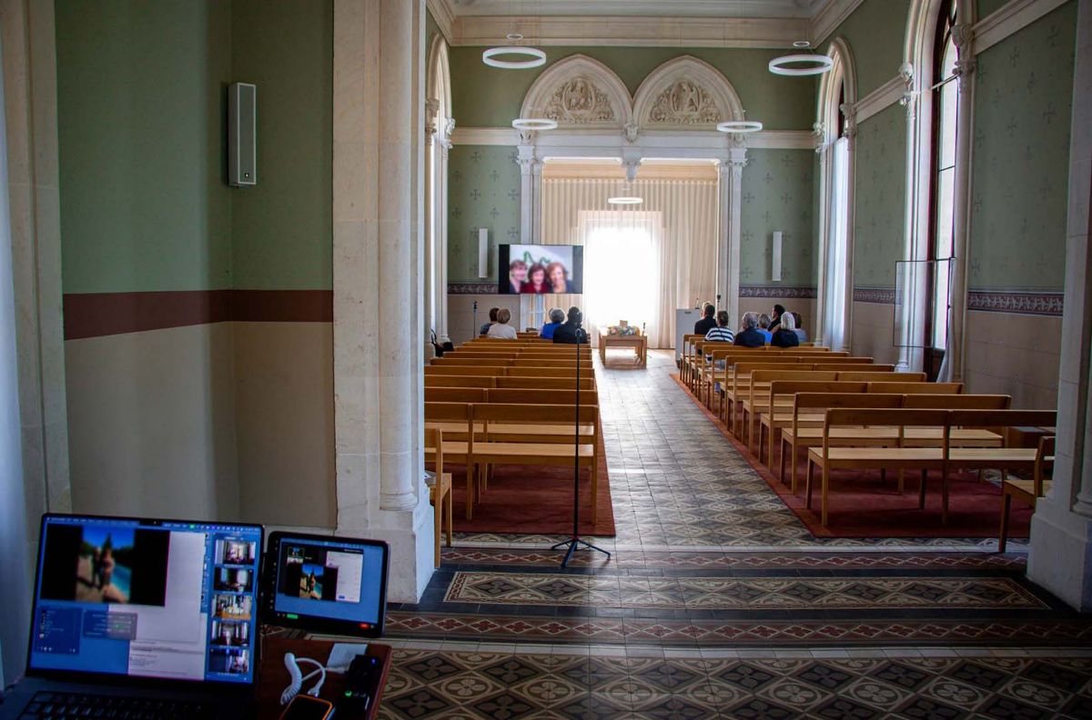Chapelle commémorative avec un portrait à l'écran pendant une cérémonie diffusée en direct